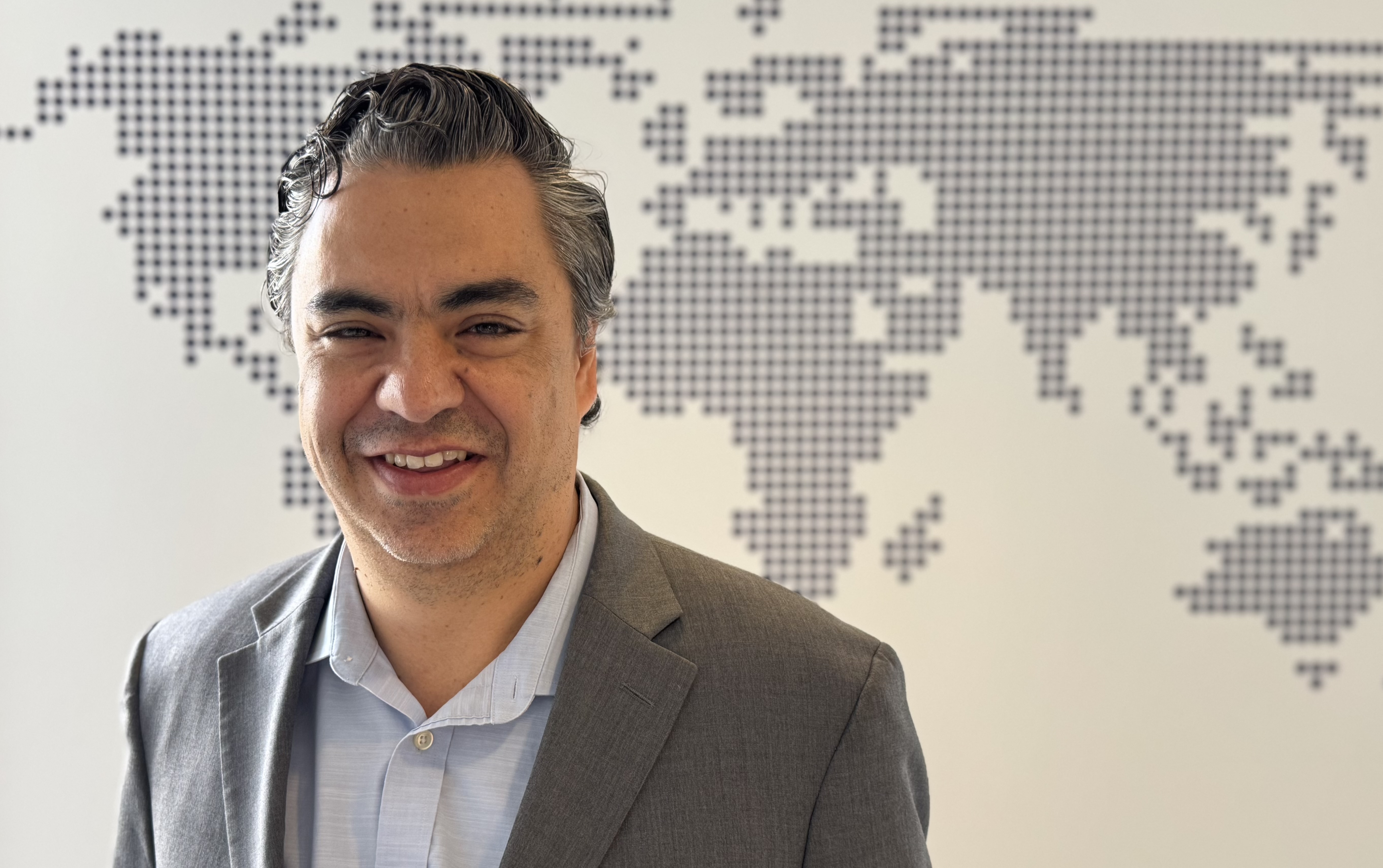 Portrait of World Justice Project Chief Research Officer in front of a digitally stylized world map