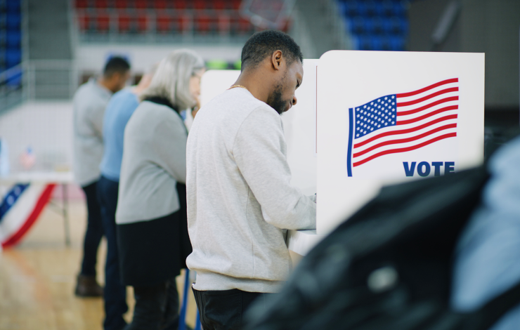 three people at voting stations 